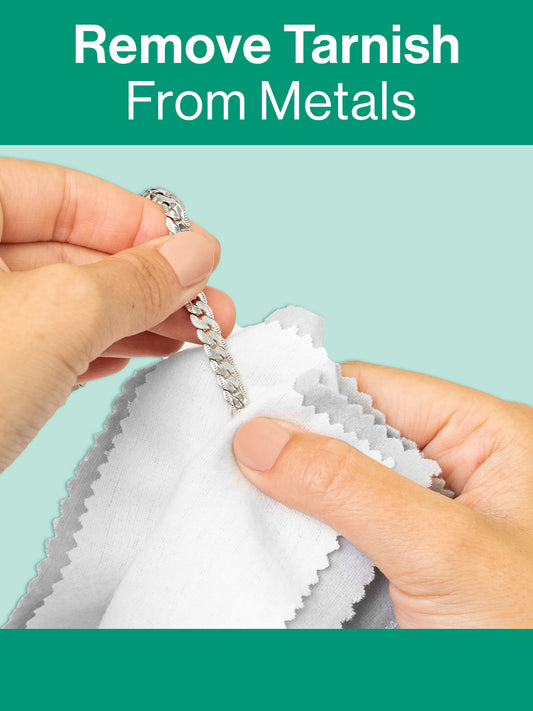 Hands using the GEM GLOW Gold & Silver Polishing Cloth's treated inner layer to remove tarnish from a silver bracelet.