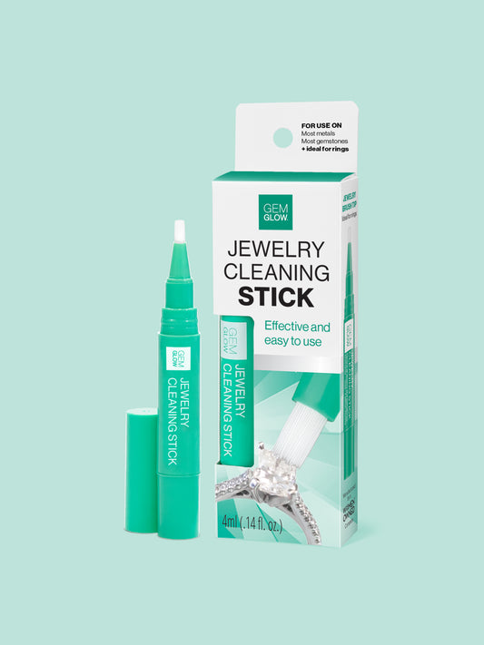 Outer packaging of the GEM GLOW Jewelry Cleaning Stick next to the Stick uncapped to display brush head.