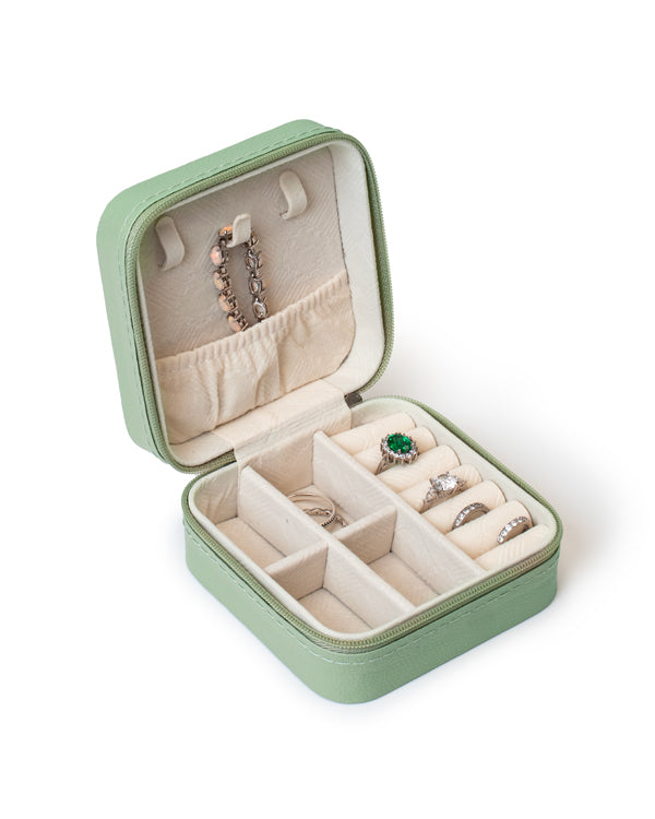 The GEM GLOW Jewelry Storage Case open with a necklace, bracelet and four rings secured inside the proper compartments.