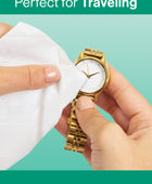 Hands using a Gem Glow Jewelry + Watch Cleansing Wipe to clean a gold watch face.