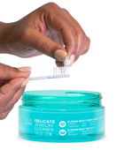 Hands cleaning a pearl ring using Delicate Jewelry Cleaner