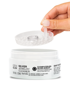 Hand dipping a silver ring into a jar of Silver Jewelry Cleaner