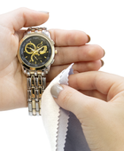 Hands cleaning a metal watch with a Gold & Silver Polishing Cloth